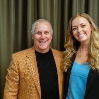 Two guests smiling in front of a backdrop at Scholarship Dinner 2019
